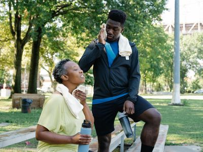 Water bottle and towel on a bench near windows.